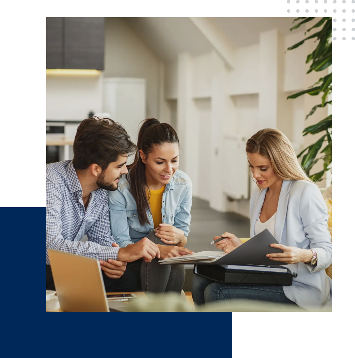 Three young professionals collaborating over documents in a modern office.