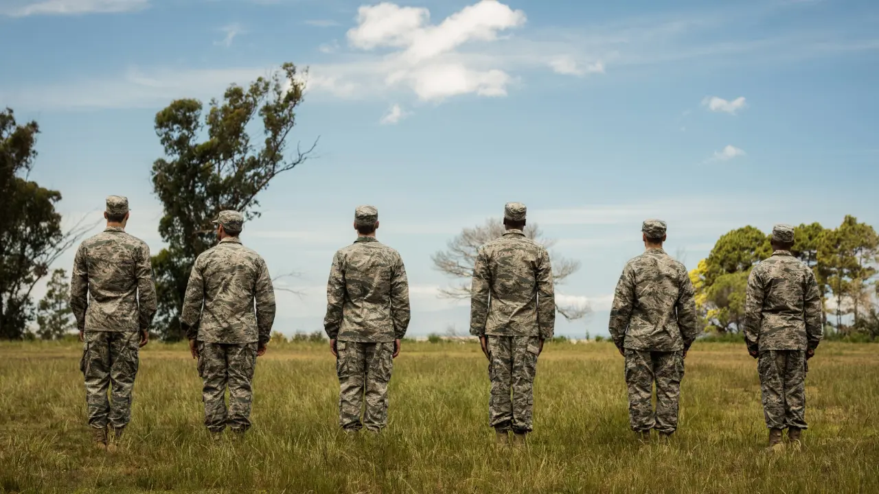 Soldiers standing in a line outdoors.