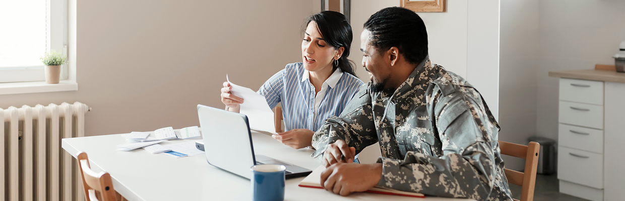 Two people discussing documents at table.