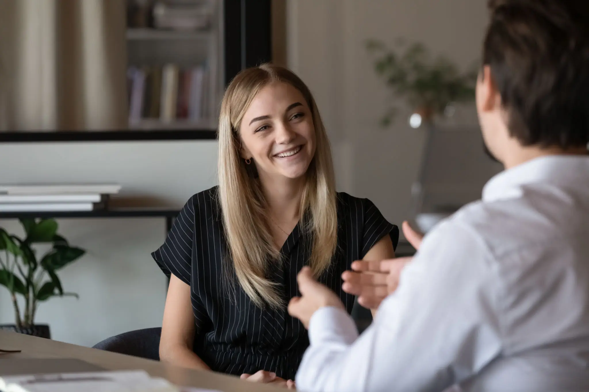 Two people engaged in a friendly conversation indoors.